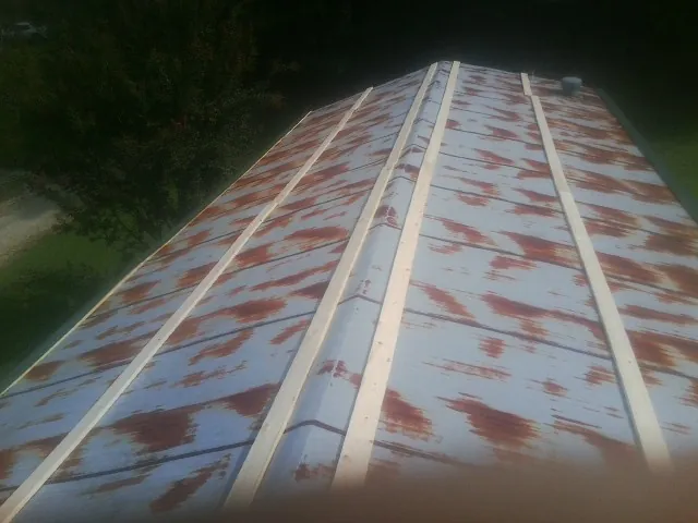 Rusted metal roof panels with new wood purlins before replacement — Storm Damage Roof Repair in Sidman by Roofing Brothers