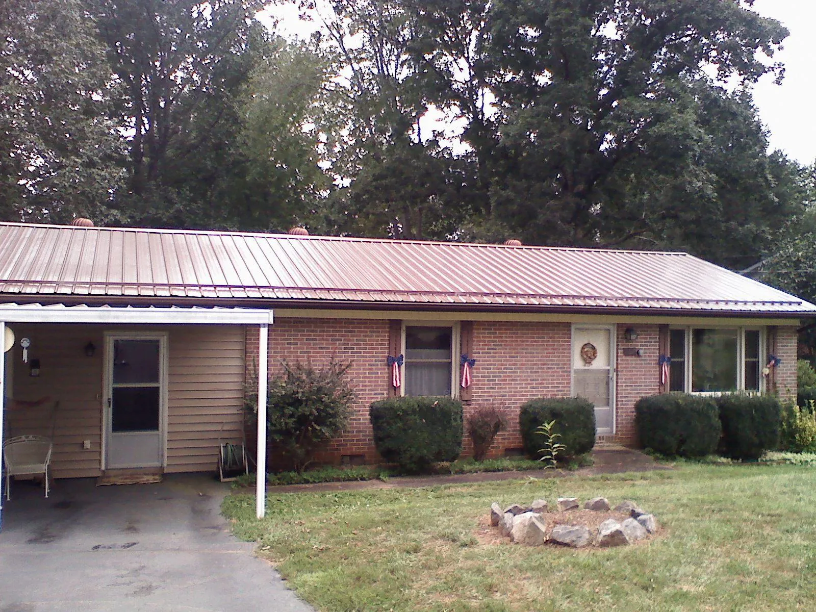 Bronze metal roof and carport on a brick ranch home — Roof Repair work by our crew in Sidman