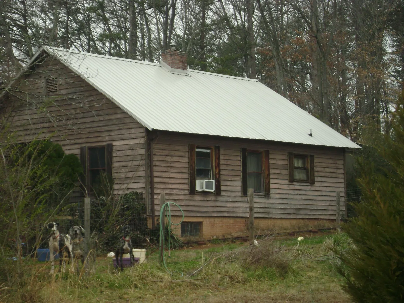 White metal roof on an old wood sided farmhouse, from a Metal Roof Installation job in Sidman